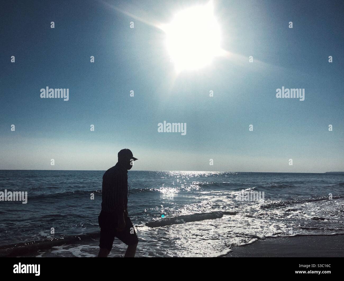 Silhouette of a man walking by the beach - Smartphone Captured Stock Image