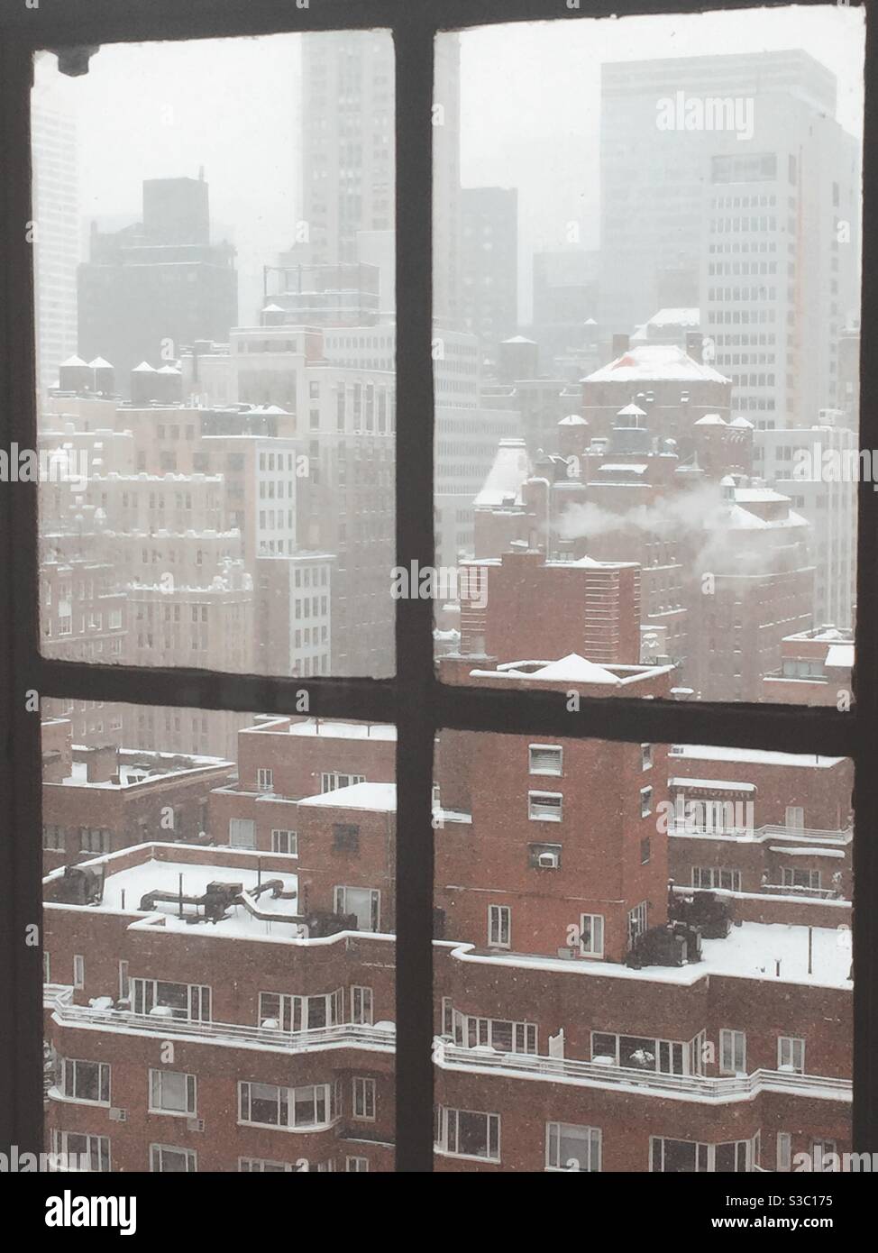 The Murray Hill neighborhood in Midtown Manhattan discovered in a blanket of snow doing a December snowstorm as seen from an apartment window, NYC, USA - Smartphone Captured Stock Image