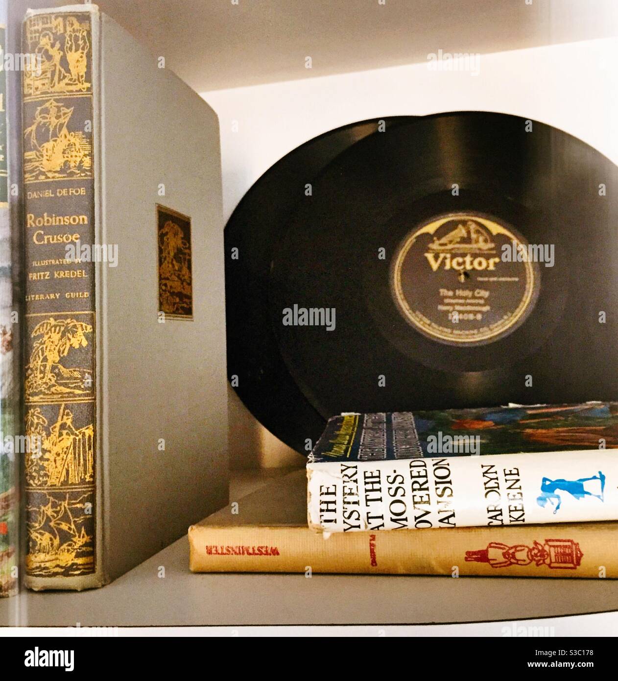 Vintage books and record on a residential bookshelf, United States