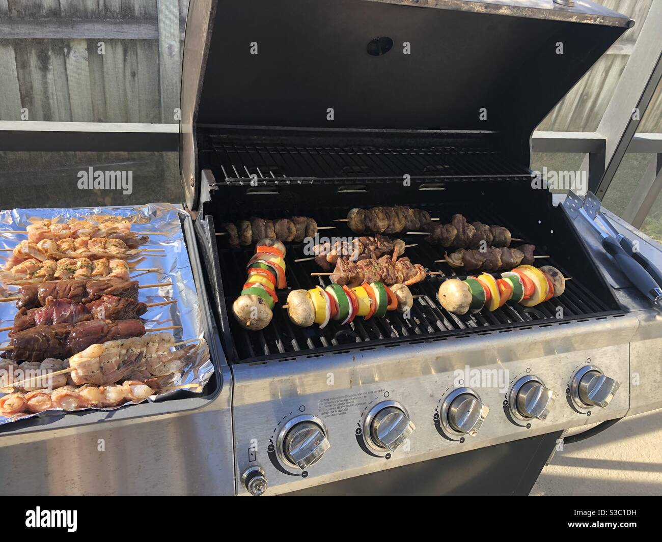 Grilling good meat and vegetable kebabs. Stock Photo
