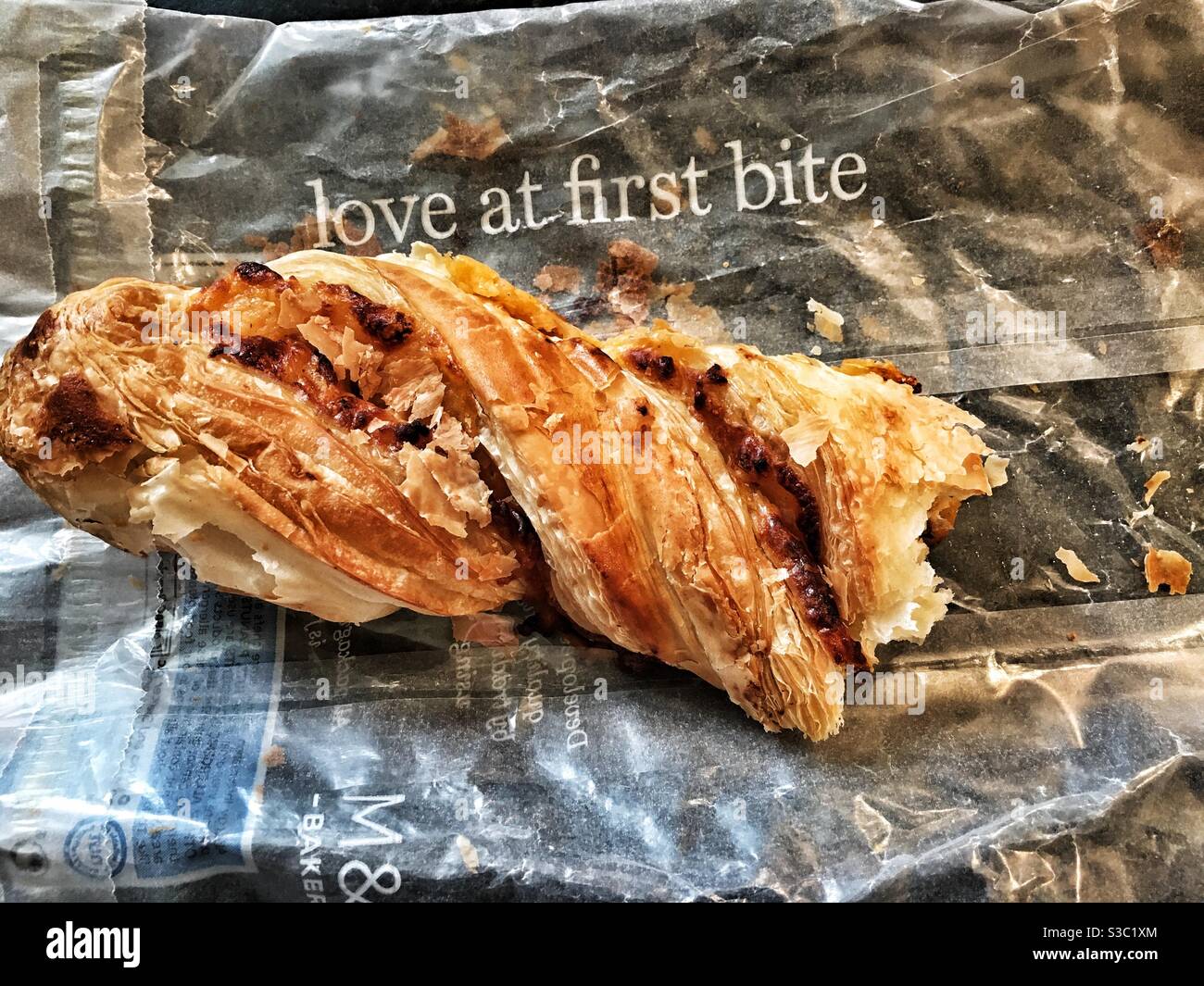 Marks and Spencer cheese and onion twist with a bite taken out. - Smartphone Captured Stock Image