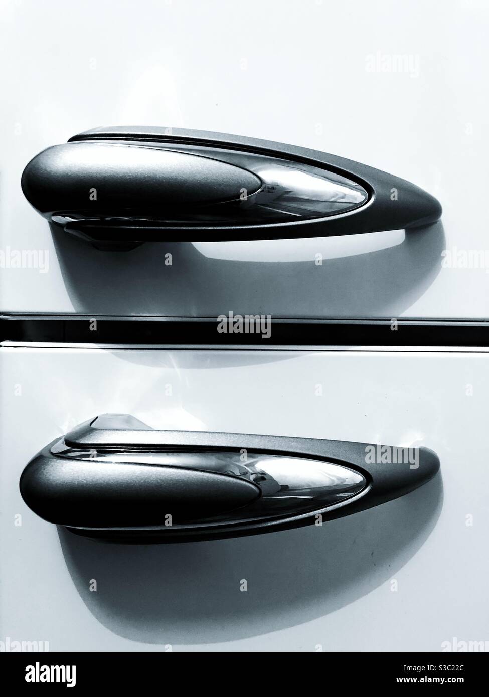 The shiny metallic handles of a retro style fridge or refrigerator - Smartphone Captured Stock Image