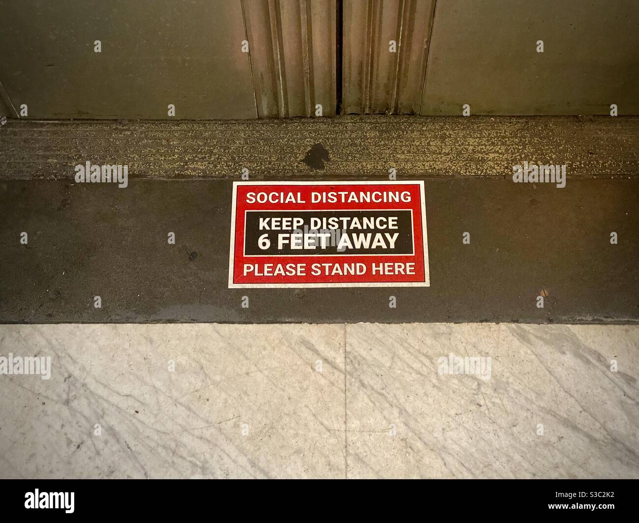 LOS ANGELES, CA, SEP 2020: red and black sign on floor by elevator entrance, showing social distancing rules during Covid-19 coronavirus pandemic in Downtown Los Angeles - Smartphone Captured Stock Image