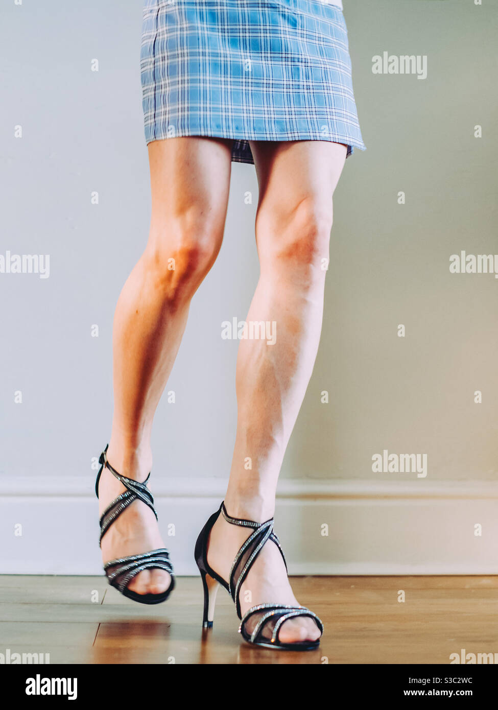 Woman wearing a blue shirt skirt and open toe high heels sandals - Smartphone Captured Stock Image