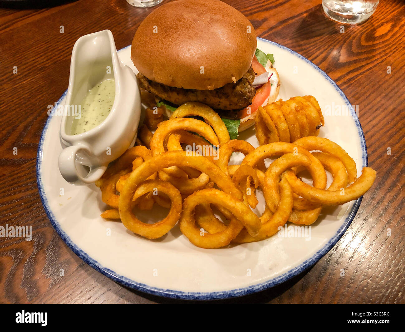 A pub lunch consisting of burger and curly fries. - Smartphone Captured Stock Image