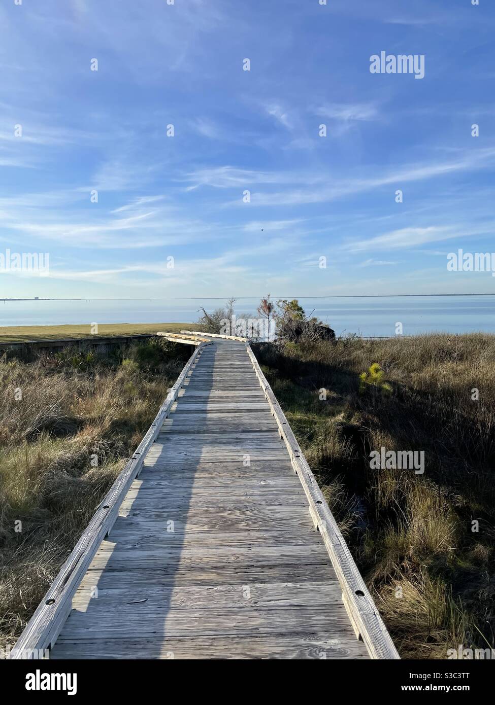 Old wooden bridge over preservation area with view of the blue water of the Choctawhatchee Bay Florida - Smartphone Captured Stock Image