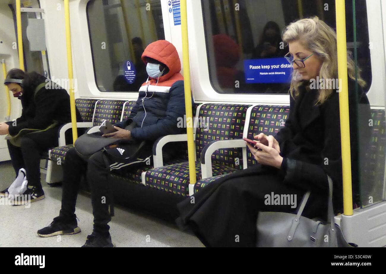 LONDON UNDERGROUND TRAIN PASSENGERS, WEARING A FACE MASK AND NOT
