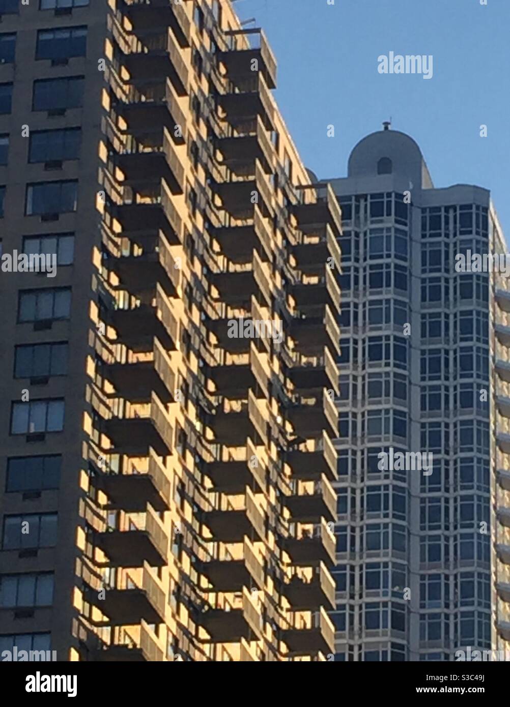 The low winter sun lights up balconies on an apartment building on third Avenue in Manhattan, NYC, USA - Smartphone Captured Stock Image
