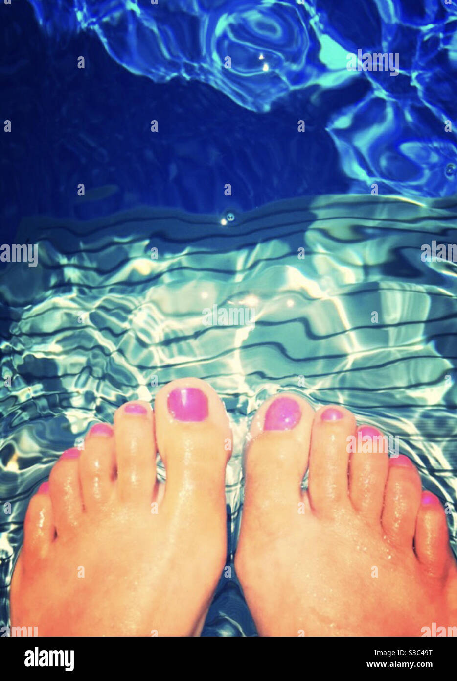Toes dipped in pool Stock Photo