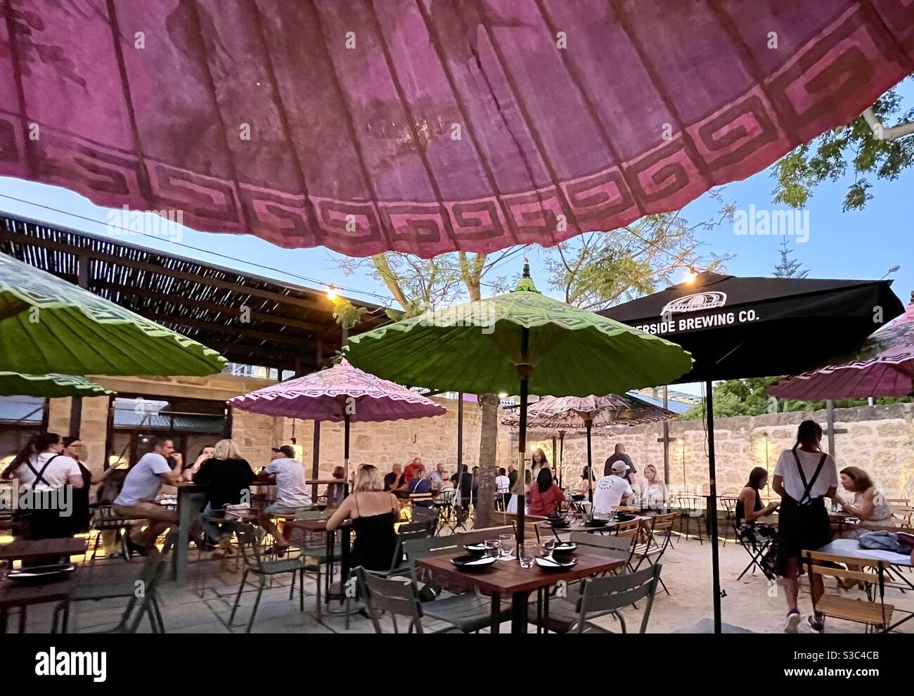 Courtyard Al fresco dining under colourful umbrellas at Emily Taylor restaurant Fremantle Western Australia Stock Photo