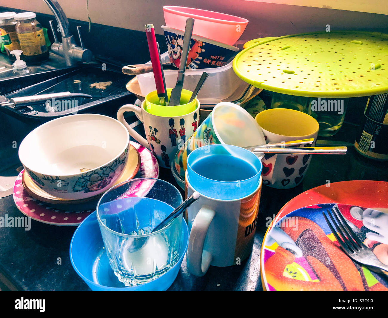 Piles if washing up with dirty cups, plates and dishes piled next to the kitchen sink. - Smartphone Captured Stock Image