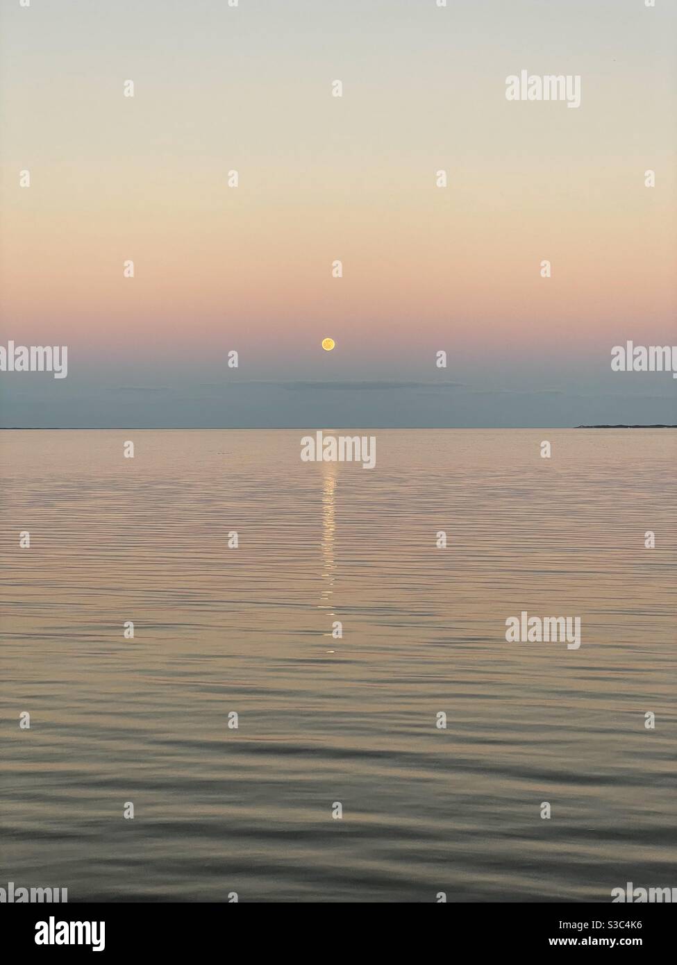 Last full moon of 2020 with sunset skies over bay water - Smartphone Captured Stock Image