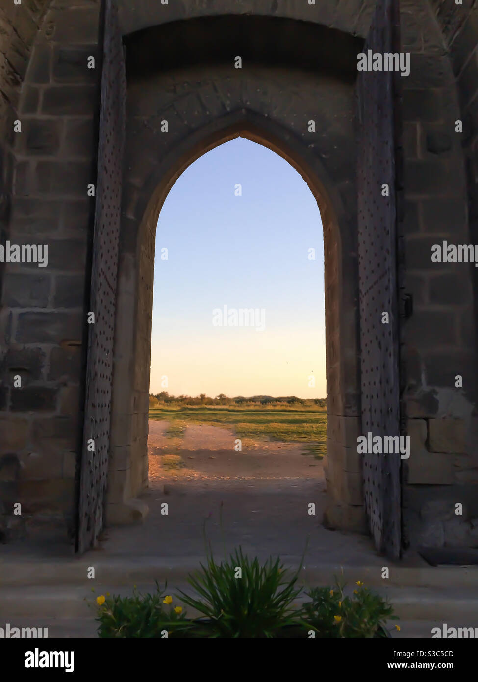 open gate of medieval stone wall enclosure at sunset in Aigues-mortes, Camargue, France - Smartphone Captured Stock Image