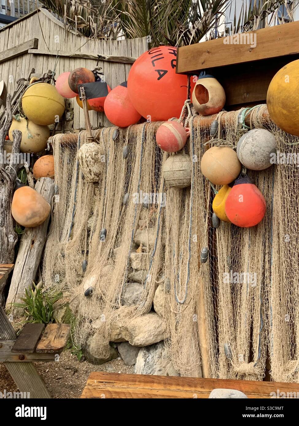 Drying nets and colourful plastic buoys at the beach on the Isle of Wight. Stock Photo