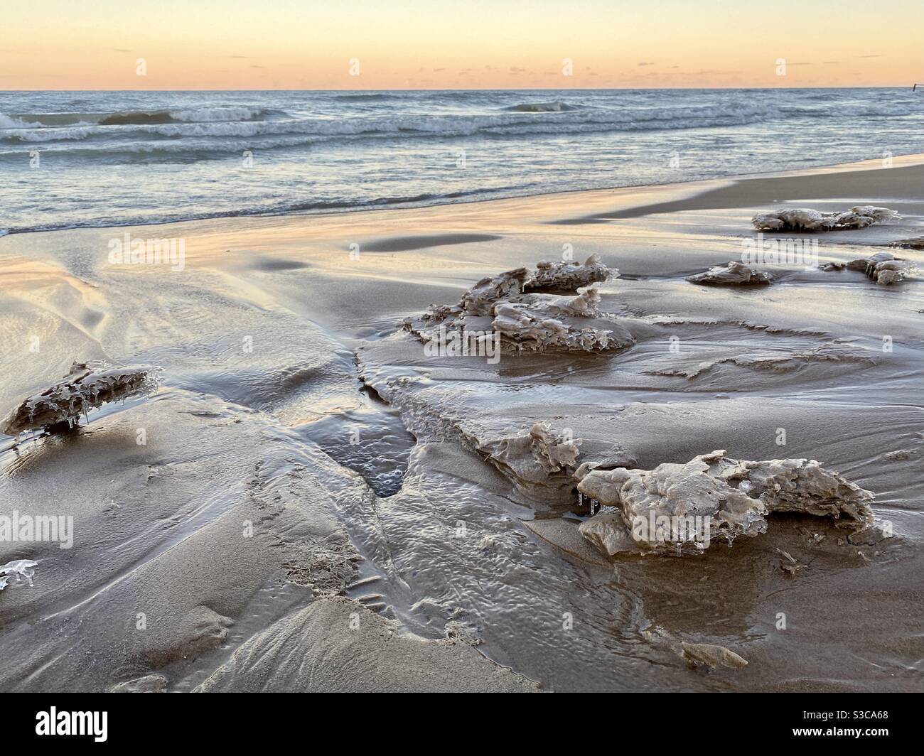 Waves from Lake Michigan leave icy carvings on Gillson Beach along the Illinois shore on a winter’s day. Stock Photo