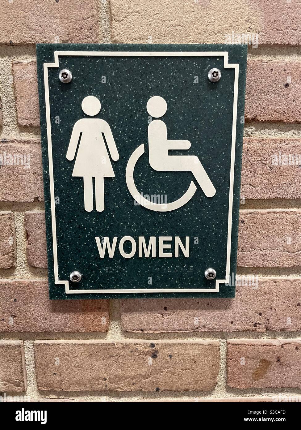 Restroom sign for women and handicap on a brick background Stock Photo