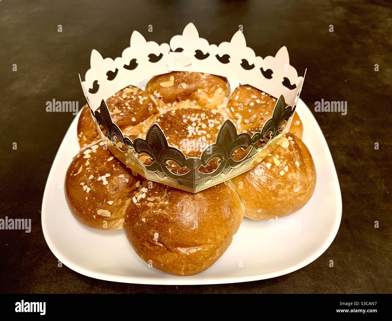 King‘s cake or Three Kings‘ cake is sweet pastry baked in German speaking countries on the occasion of the Epiphany. It is decorated with a paper crown. Stock Photo