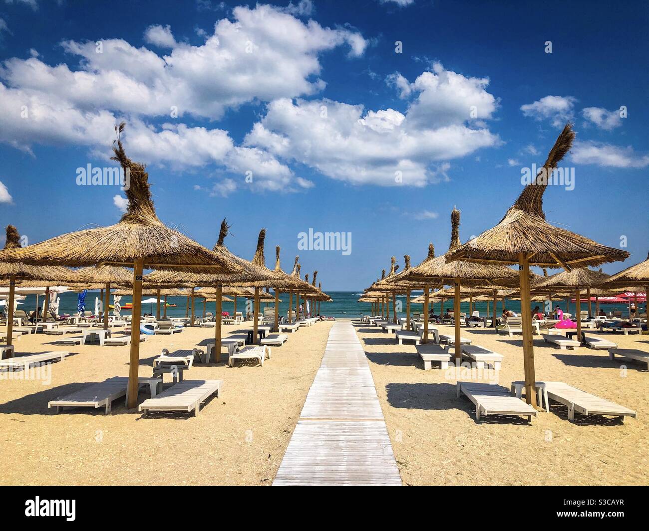 Empty beach with thatched roofs umbrellas - Smartphone Captured Stock Image