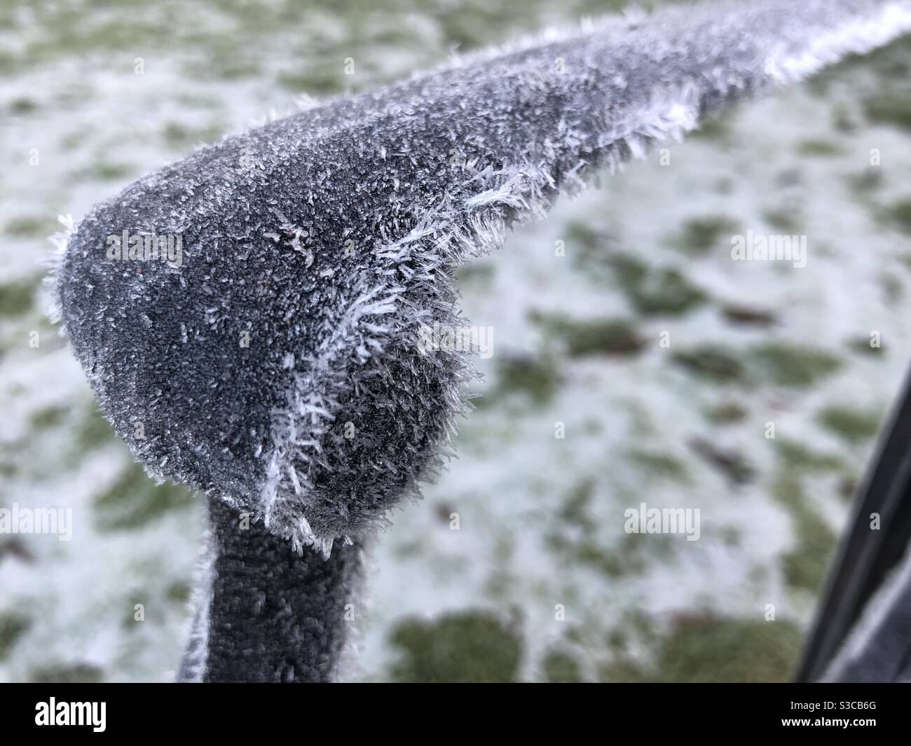 Ice crystals on the arm of a metal chair in a garden in winter, United Kingdom Stock Photo