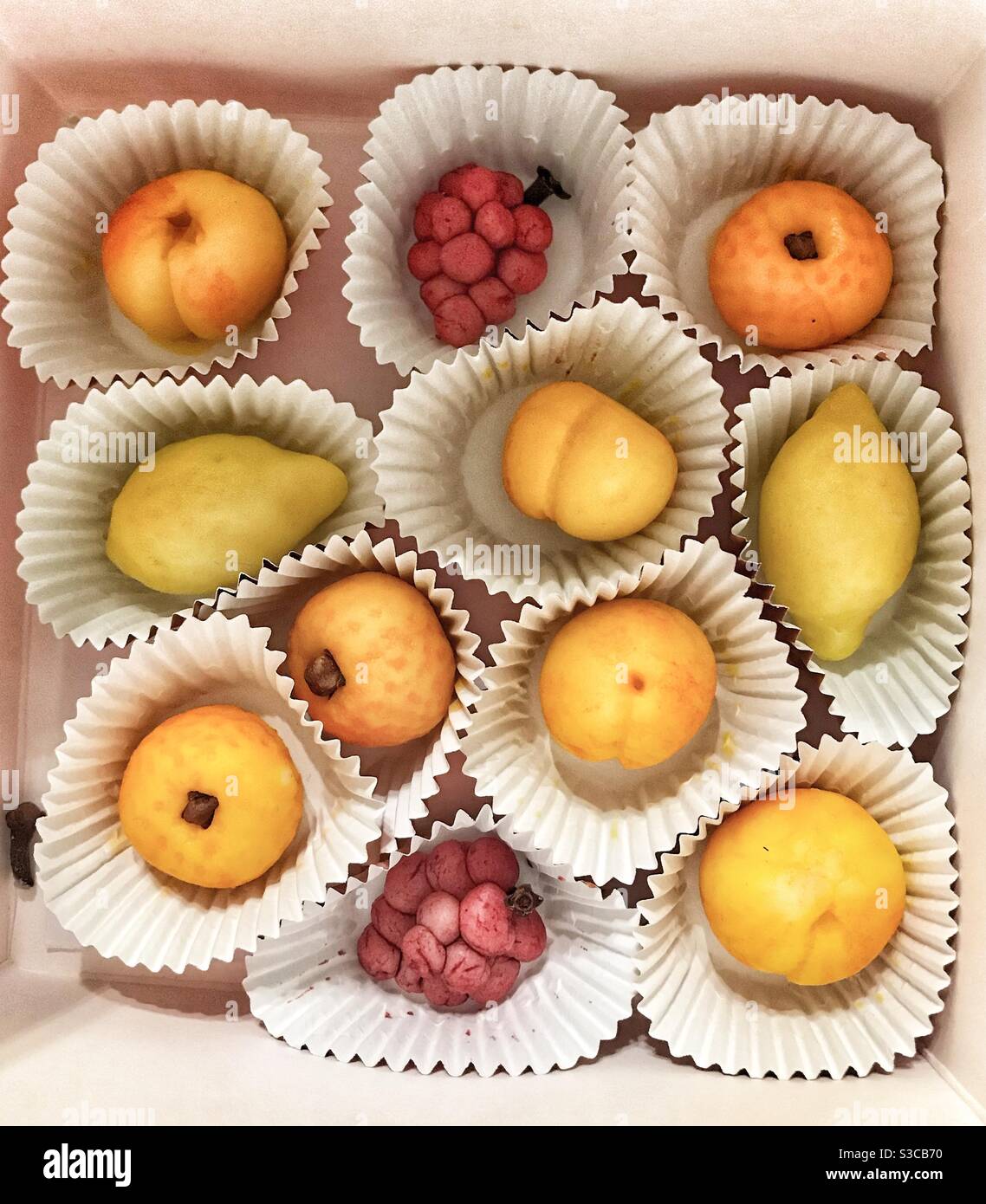Selection of Homemade Marizipan Fruits in Petit Four Cases presented in a box Stock Photo