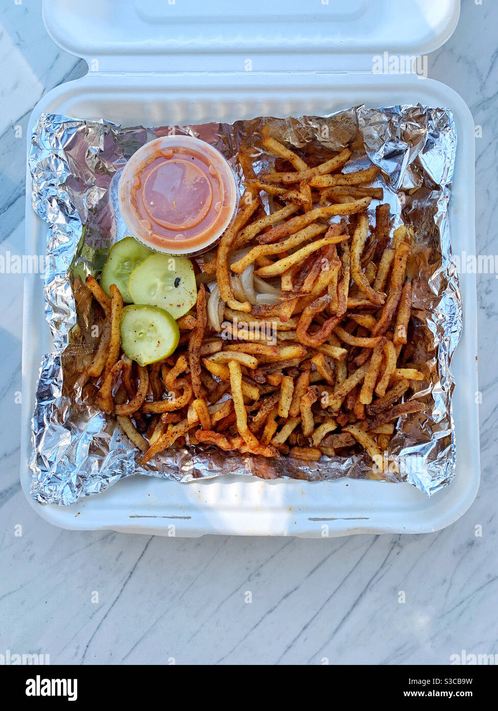 French fries in a recycled paper container with aluminum foil lining - Smartphone Captured Stock Image