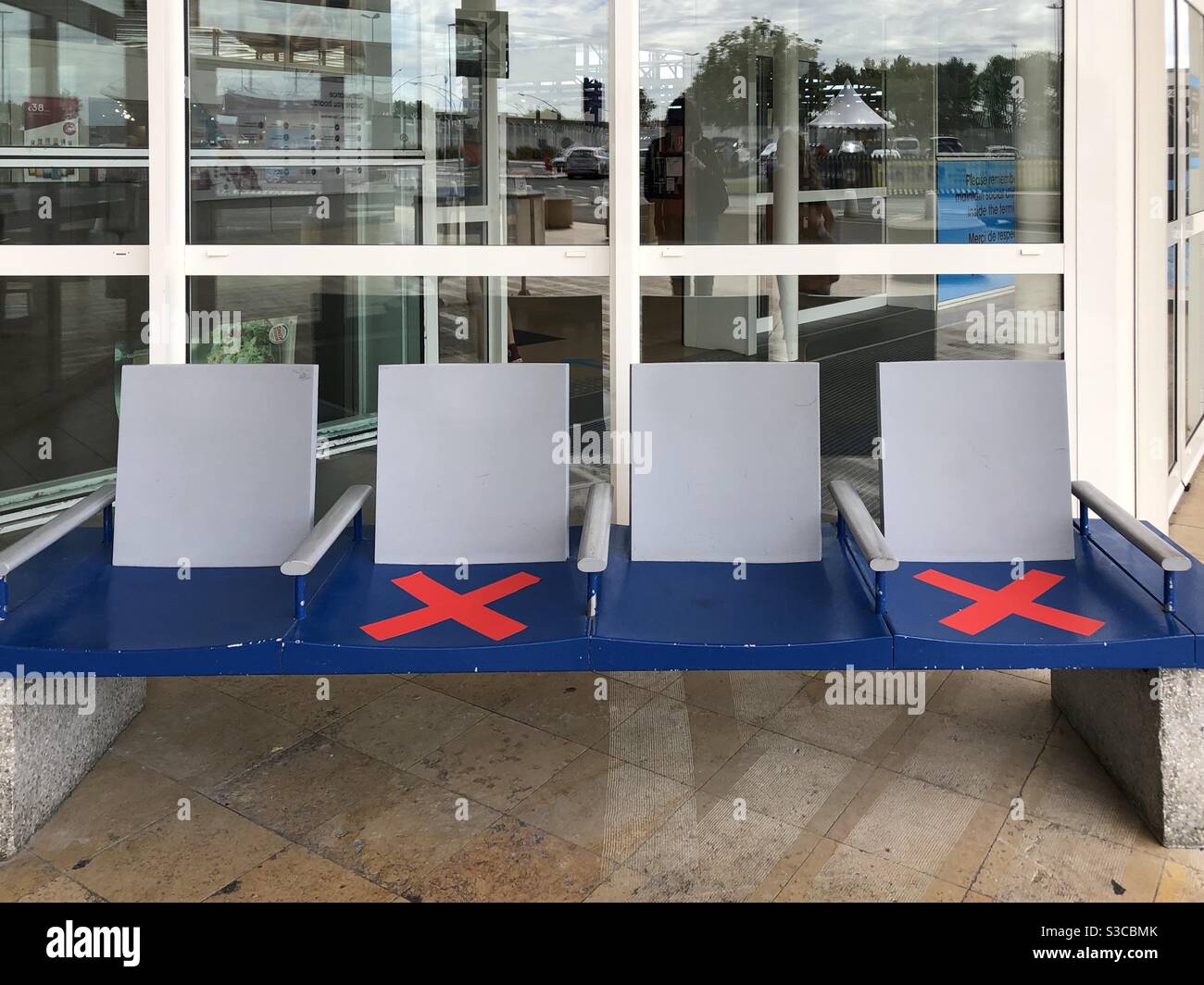 Row of seats with red crosses taped on every other seat - Smartphone Captured Stock Image