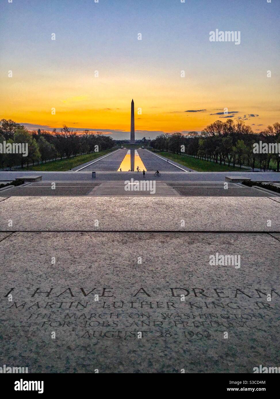 The sun rises above the the steps of the Lincoln Memorial on National Mall in Washington DC. In the foreground are the famous words of Martin Luther King from his I Have a Dream speech. Stock Photo