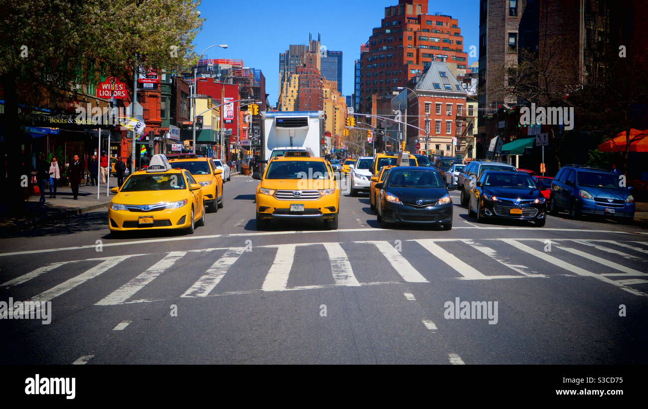 Yellow taxis in a typically Manhattan street scene on a bright early spring day, New York, USA Stock Photo