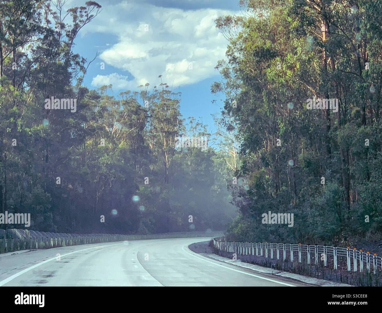 Highway, Raindrops on the windscreen and foggy steam riding up off the hot road after Summer rain - Smartphone Captured Stock Image