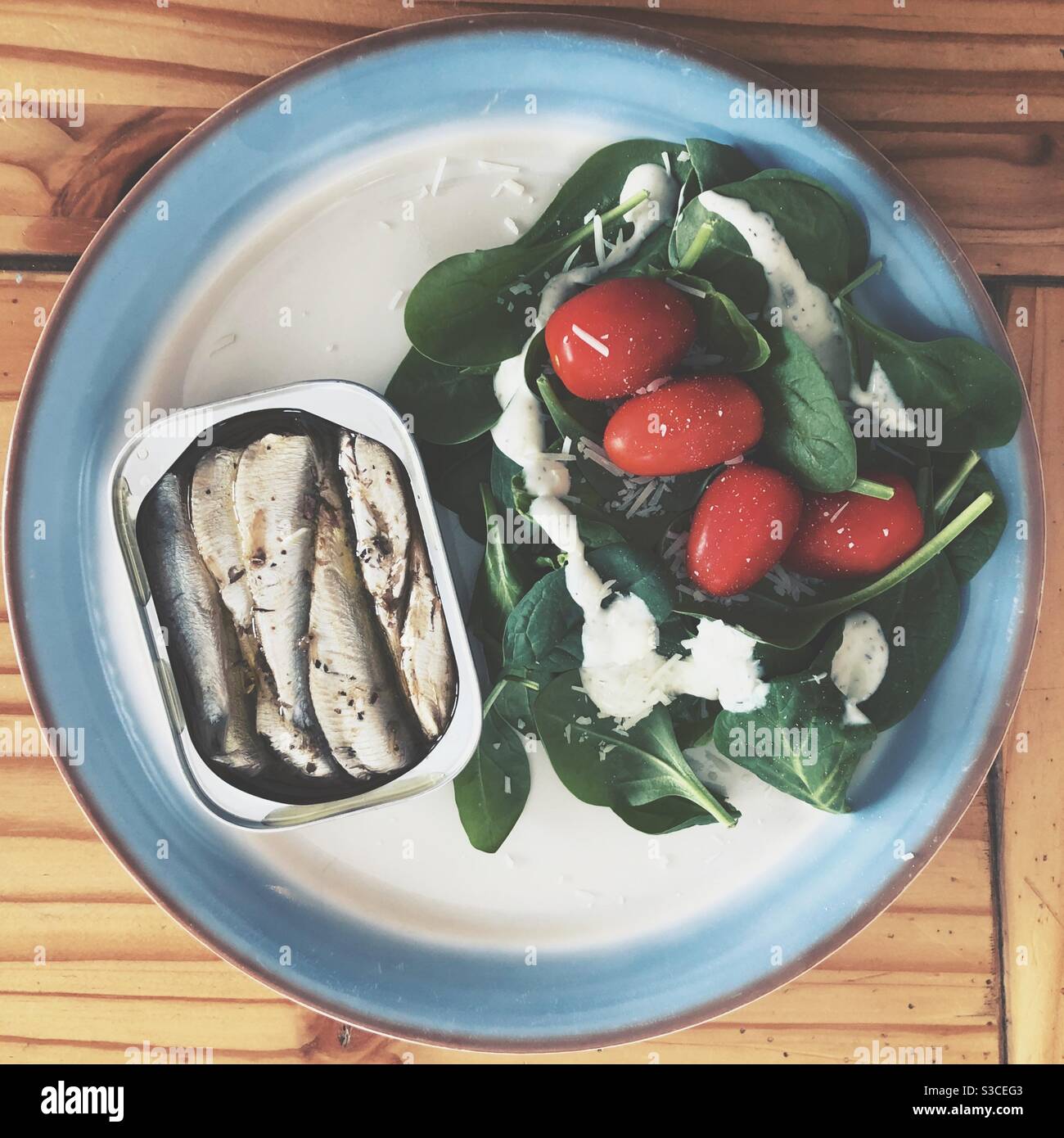 Canned sardines with spinach salad on a plate - Smartphone Captured Stock Image