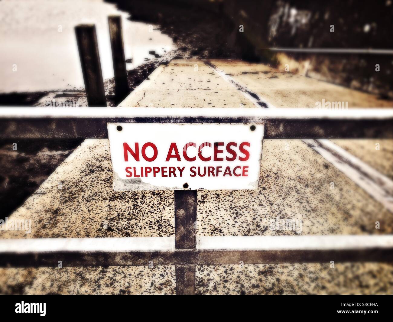 No Access Slippery Surface sign on a metal barrier Stock Photo