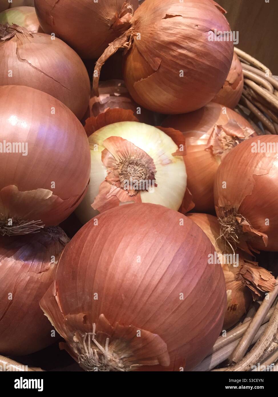 Close up of a basket of onions for sale in the produce aisle of a supermarket, USA - Smartphone Captured Stock Image