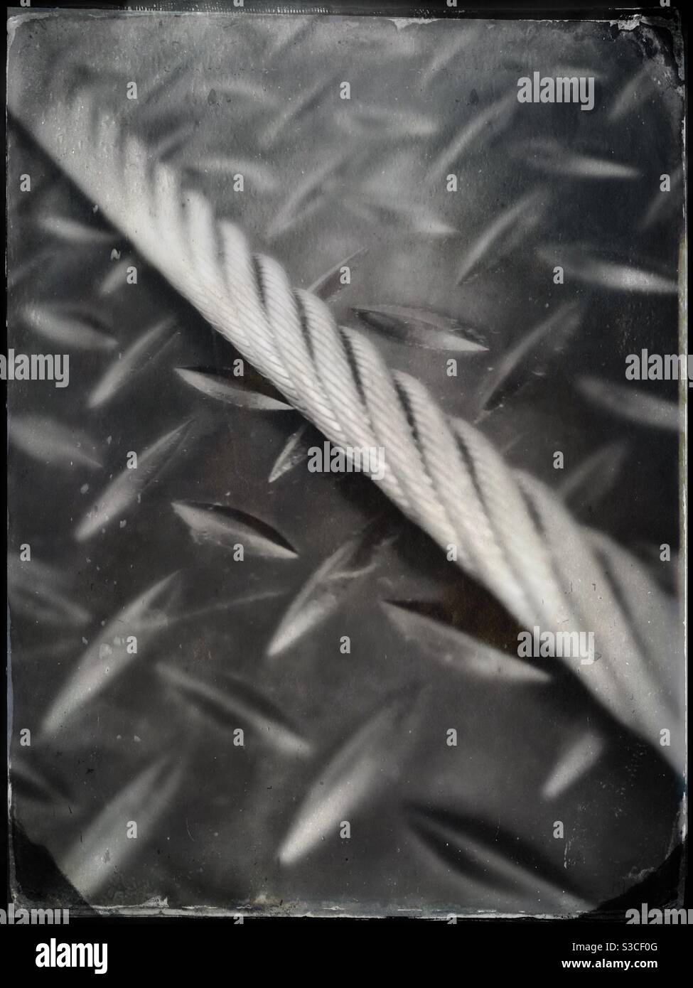Steel cable on metal Diamond plate surface - Smartphone Captured Stock Image