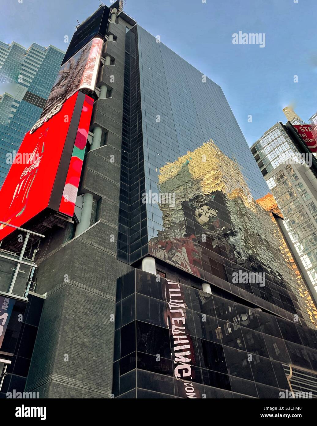 Are you drawn more toward the bright red Coke marquee or the interesting reflections  on the glass-lined skyscraper? Times Square is a visual feast in New York City,USA. - Smartphone Captured Stock Image