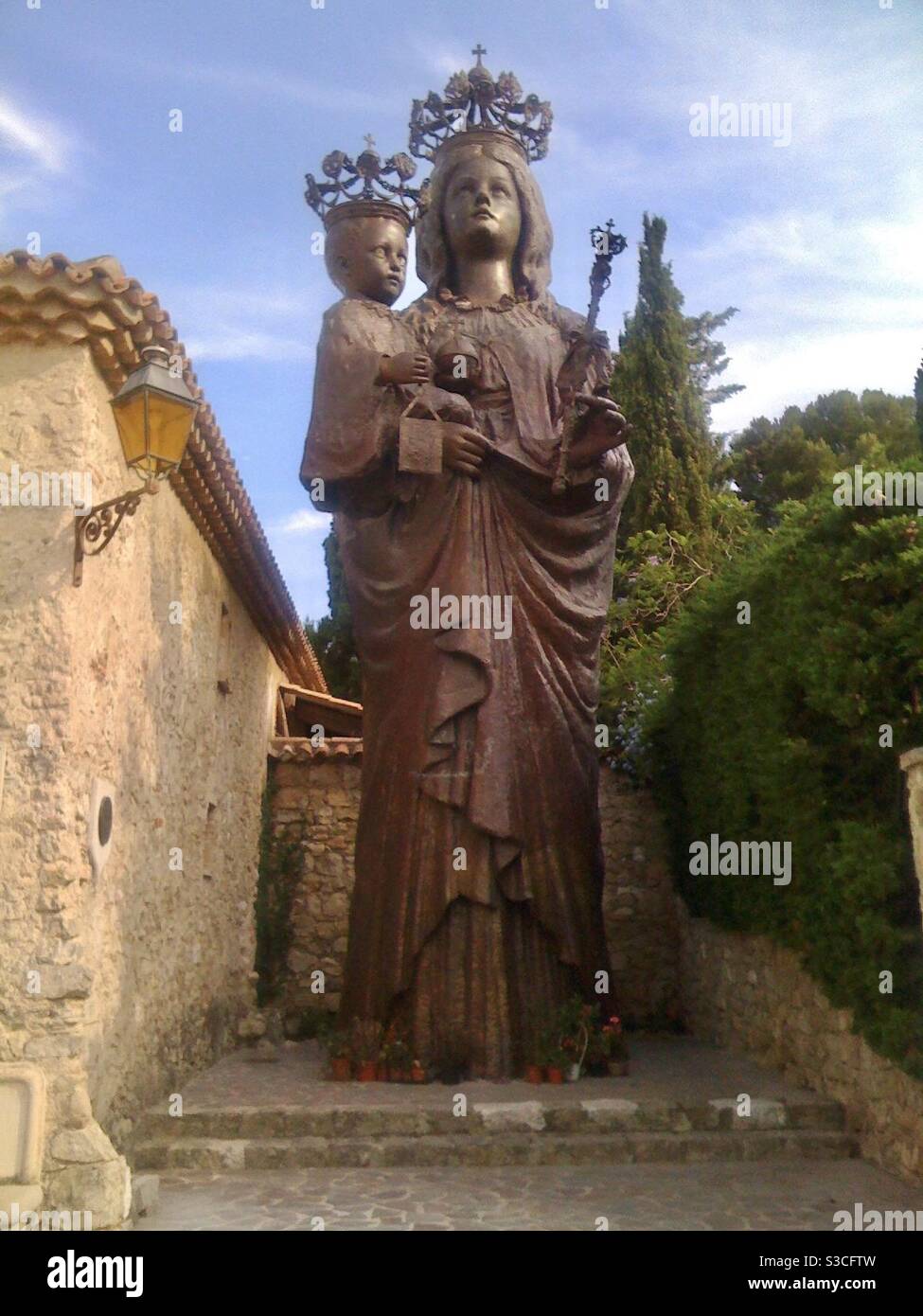 Giant metal statue of the Virgin Mary (Madonna) with baby Jesus by an old house in St Jean Cap Ferrat, Nice, France. Stock Photo