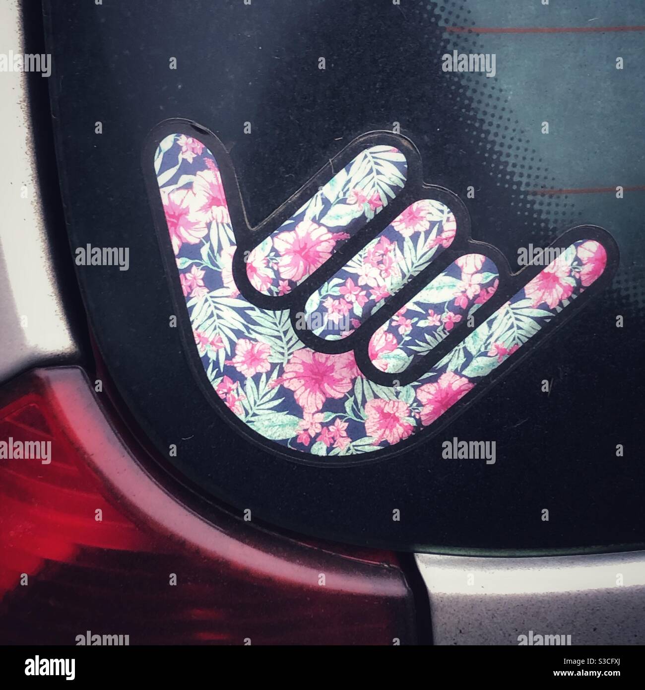Hang loose hand gesture sticker on the rear screen of a car Stock Photo