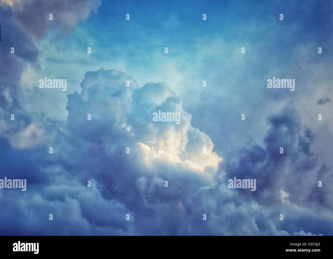 Dramatic blue storm clouds with bright spot. - Smartphone Captured Stock Image