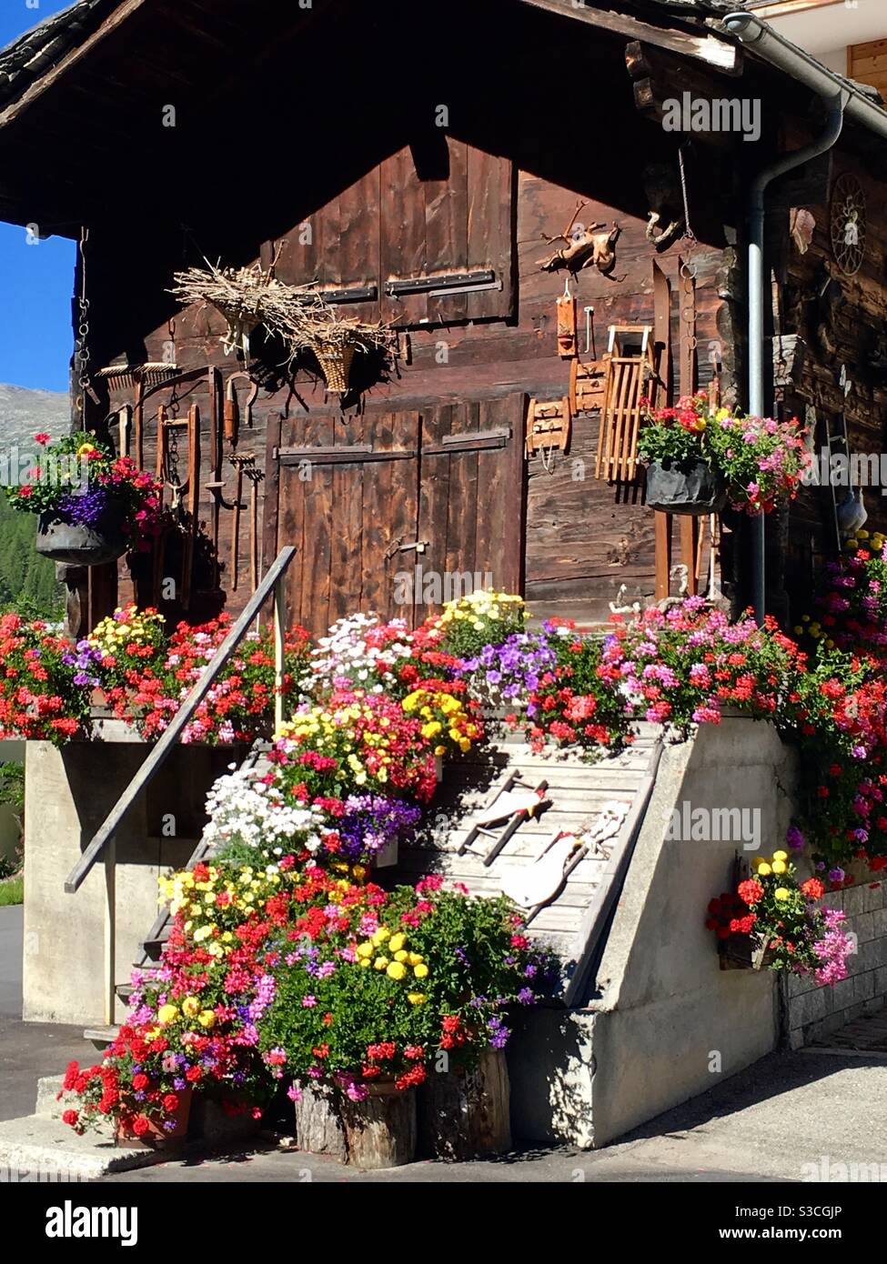 Old wooden cabin with flower decoration, Saas Grund, Valais, Switzerland Stock Photo