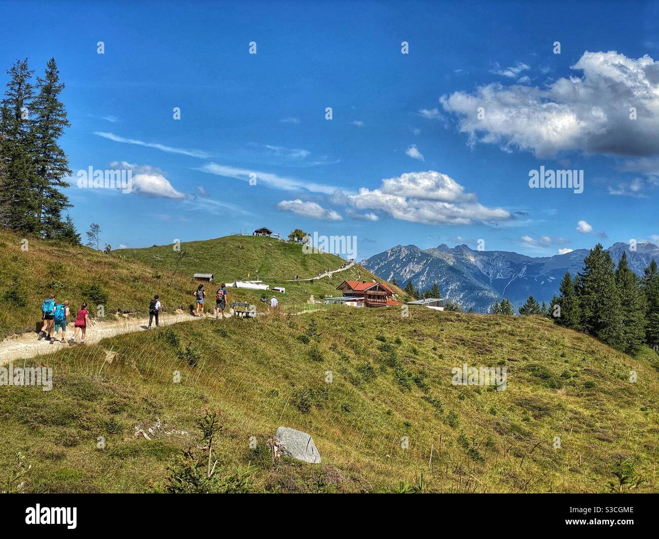 People hiking on the top of Kranzberg mountain (1397m) with view at