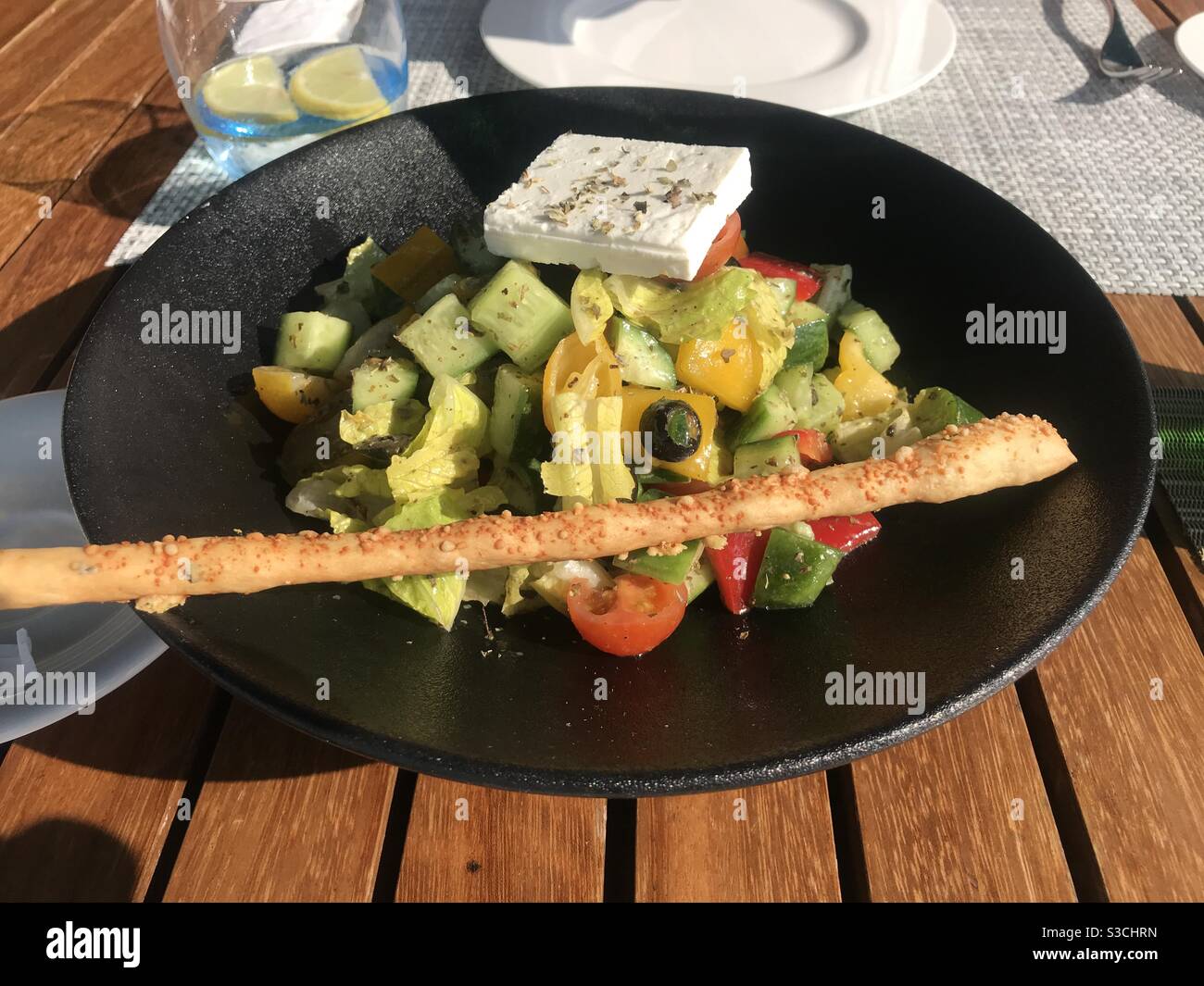 Greek salad served at an outdoor restaurant terrace - Smartphone Captured Stock Image