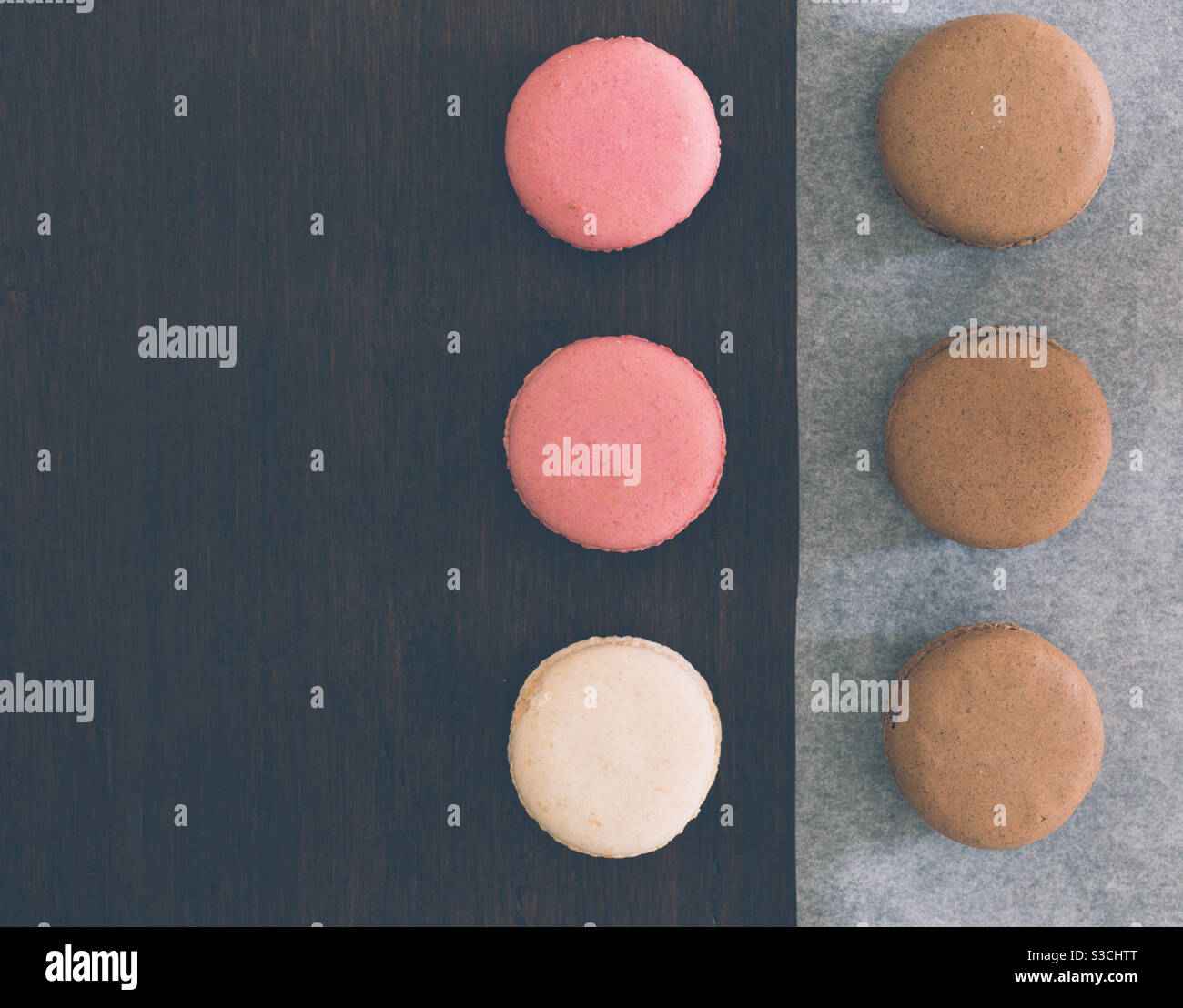 Flat lay of Delicious homemade french chocolate and strawberry macaroons or macarons arranged on a table top with copy space - Smartphone Captured Stock Image