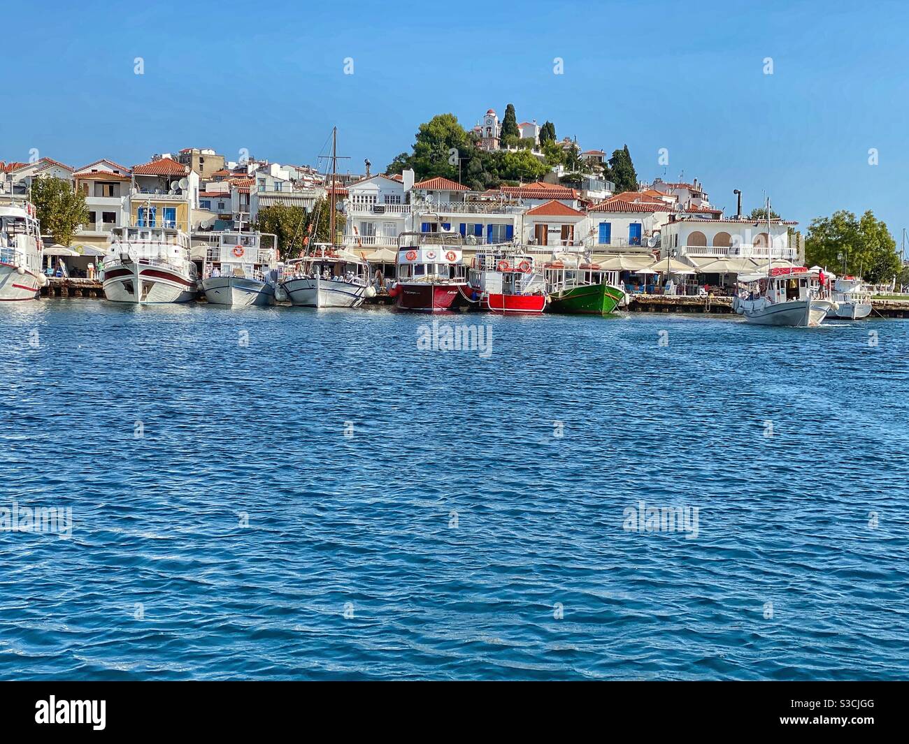 Boat view at Skiathos town, port and St. Nicholas church on the hill. - Smartphone Captured Stock Image