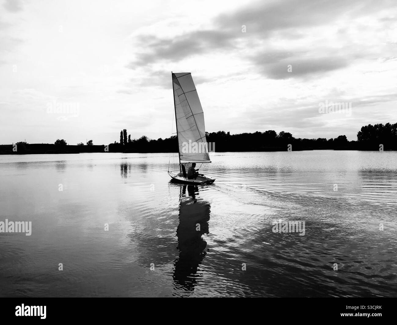 Black and white photo of boat on the lake reflecting in the water - Smartphone Captured Stock Image