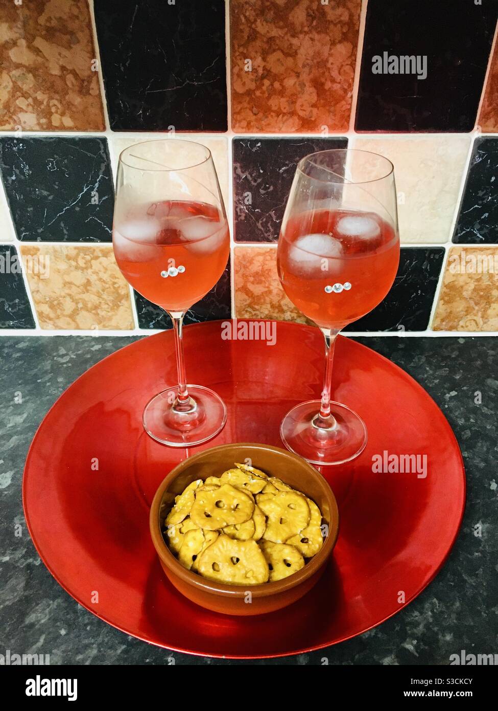 Red Gin Cocktails with pretzel snacks on a metallic red tray Stock Photo