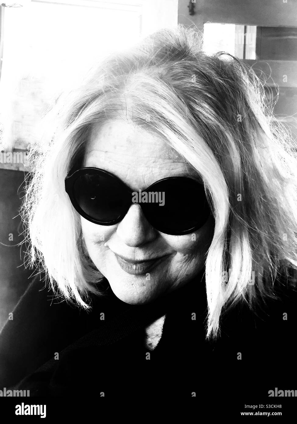 who is the beautiful mysterious blonde woman with an a enigmatic smile hiding behind sunglasses in this vintage looking black and white photo S3CKH8