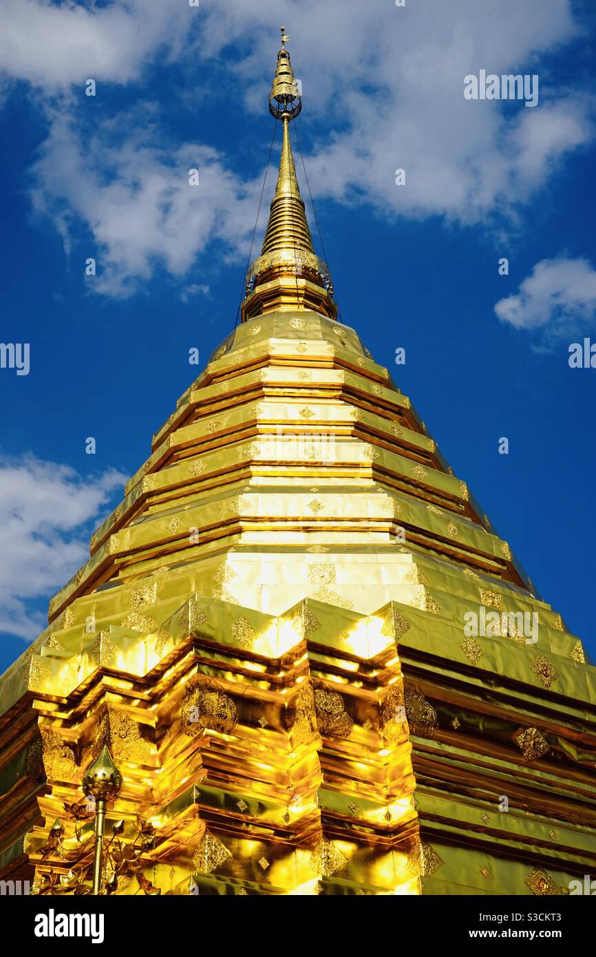 Golden temple stupa with sunlight glistening with blue sky background Chiang Mai Thailand - Smartphone Captured Stock Image