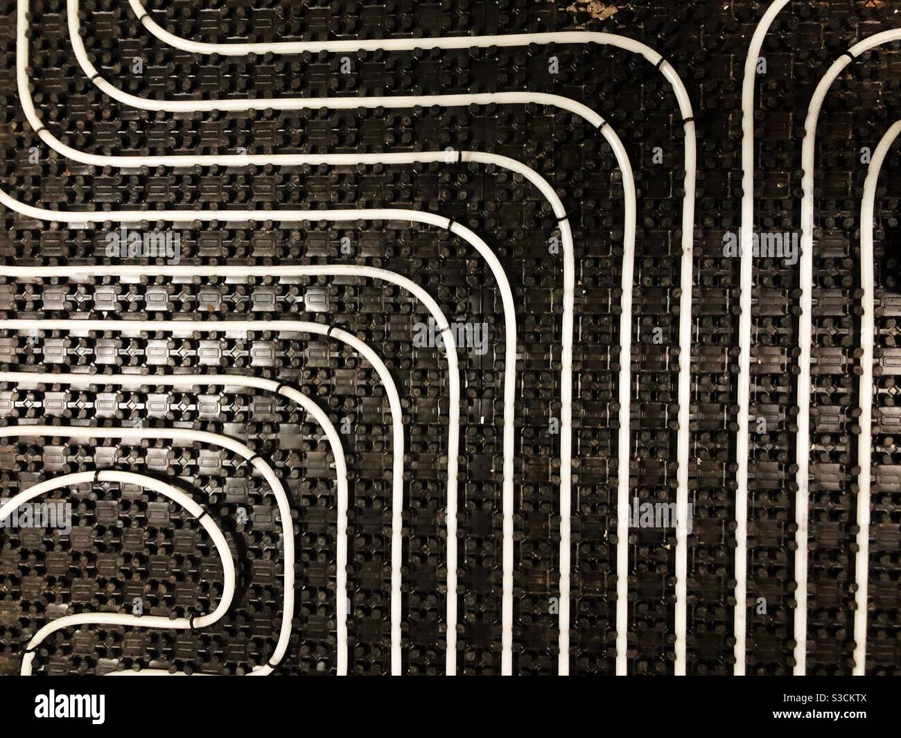 Underfloor heating tubes in a geometric pattern Stock Photo