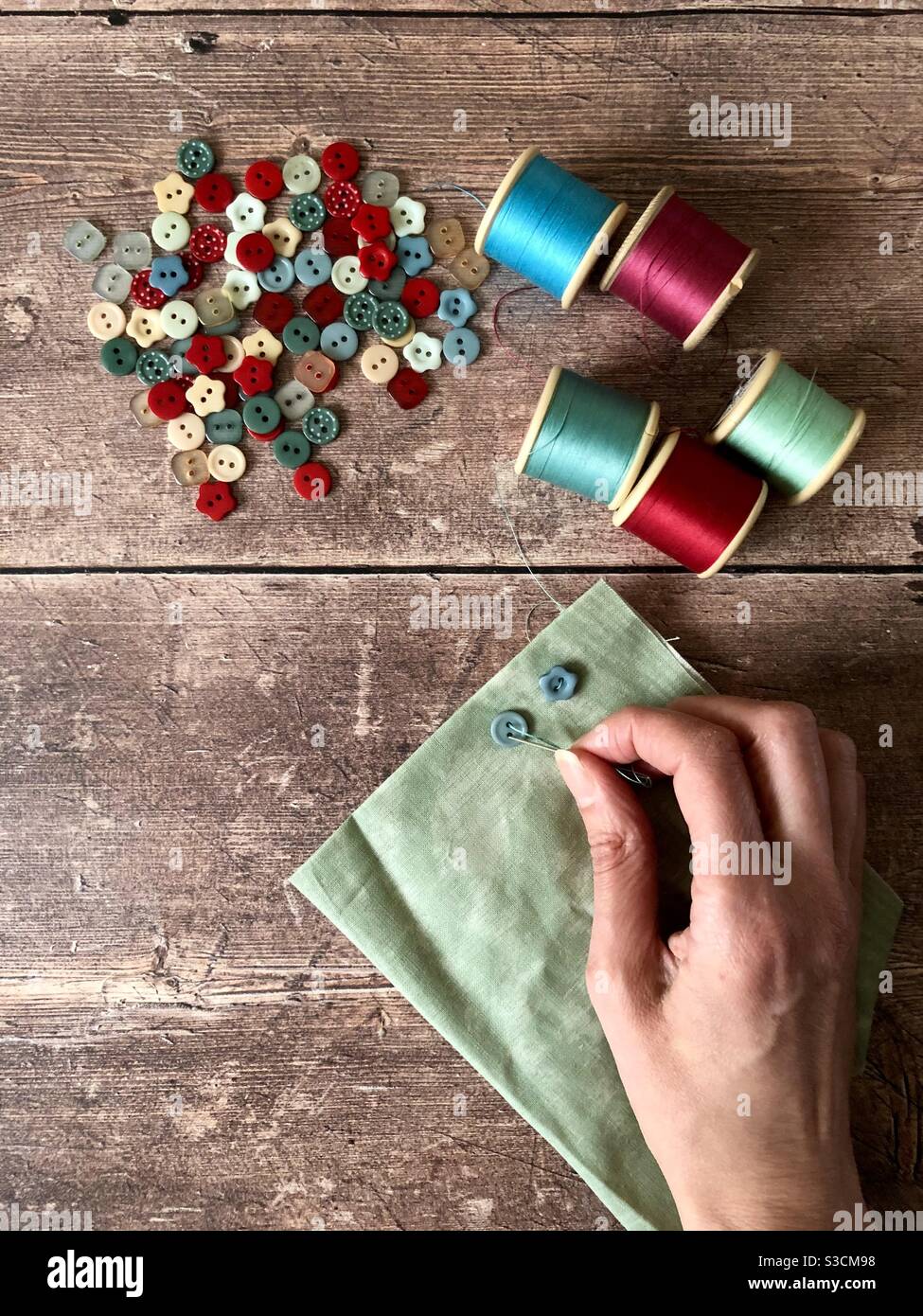 Sewing buttons onto fabric Stock Photo Alamy