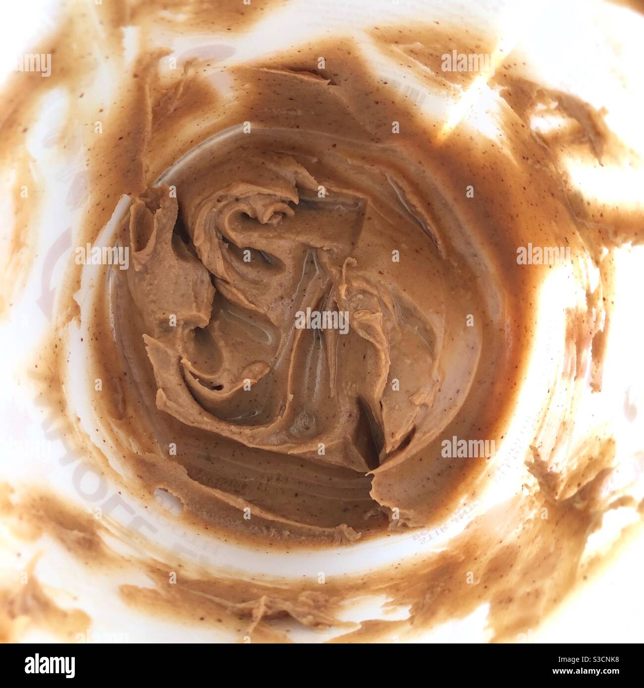 Peanut butter supplies running low as the bottom of the tub is reached. - Smartphone Captured Stock Image