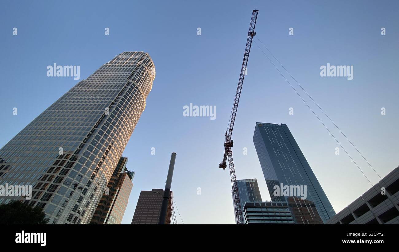 LOS ANGELES, CA, NOV 2020: looking up at construction crane, rising up next to 777 Building and other skyscrapers in the Financial District of Downtown - Smartphone Captured Stock Image